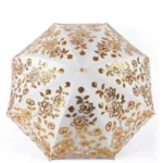 Parapluie de luxe en dentelle blanche, collection exclusive, alliant élégance, motifs floraux et protection contre la pluie.
