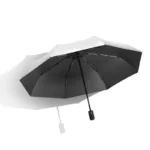 Parapluie anti-UV noir et argenté, élégant et coloré, design moderne, idéal pour protection solaire et style, sur fond blanc.