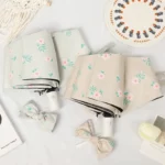 Parapluies pliables fleuris en tons pastel avec accessoires assortis, alliant élégance et praticité pour les jours de pluie.