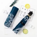 Parapluies 8 baleines motif vagues, ouverts et enroulés, design élégant, accessoires mode posés avec citrons et glaçons décoratifs.