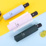 Parapluies anti-UV automatiques bleu, rose, vert, compacts et stylés, protection solaire idéale, présentés avec des citrons colorés.