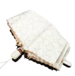Parapluie automatique avec motif de cœurs, élégant et féminin, parfait pour la pluie, sur fond blanc.