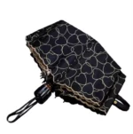 Parapluie pliable noir motif cœurs dorés, automatique et élégant, parfait pour la pluie avec une touche de style tendance.