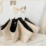 Parapluie automatique fleuri, design élégant avec motif floral sur fond beige, accessoire mode pratique et stylé pour femme.