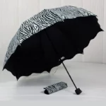 Parapluie cloche motif zèbre, ouvert avec housse assortie, design moderne et élégant pour un style unique et tendance.