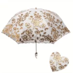 Parapluie de luxe en dentelle, élégant design floral doré sur fond blanc, accessoire raffiné de la collection exclusive.