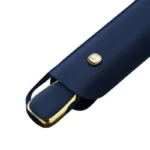 Parapluie de luxe minimaliste en cuir synthétique navy, design élégant avec fermeture dorée, idéal pour un style raffiné.