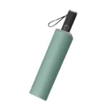 Parapluie pliant vert élégant pour femme, poignée noire ergonomique, accessoire chic pour affronter la pluie avec style.
