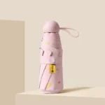 Parapluie pliable femme en forme de cœur, rose à pois jaunes, élégant et pratique, idéal pour une protection stylée contre la pluie.