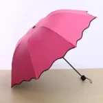Parapluie femme coloré rose vif, design élégant avec bord ondulé, parfait pour se protéger de la pluie avec style.
