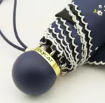 Parapluie femme léger, élégant avec manche bleu, dentelle blanche et dispositif doré, idéal pour allier style et praticité.