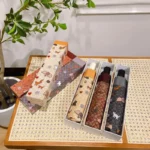 Parapluie pliant chat dans une boîte décorative, motifs d'animaux et nature, style coloré et esthétique unique.