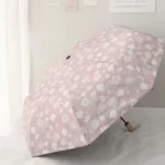 Parapluie pliant fleuri rose avec motifs floraux blancs, élégant et compact, parfait pour ajouter du style sous la pluie.