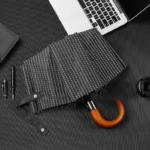 Parapluie pliant homme élégant, motif à rayures blanches sur fond noir, accessoire pratique et stylé pour toutes les occasions.