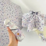 Parapluie pliant violet à motifs floraux avec accessoires assortis, parfait pour la protection contre la pluie.