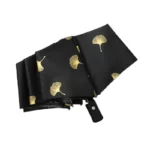 Parapluie résistant noir avec motifs dorés, alliant élégance et durabilité, parfait contre la pluie avec un design raffiné