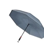 Parapluie tempête double couche gris, élégant et robuste, détail rouge sur le manche, idéal contre la pluie et le vent.