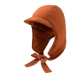 Capuche matelassée orange avec visière et attaches, chaude et imperméable, parfaite pour se protéger de la pluie en style.
