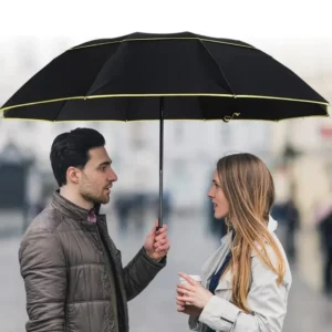 Parapluie XXL résistant noir avec bords jaunes, élégant accessoire urbain pour homme et femme par temps de pluie.