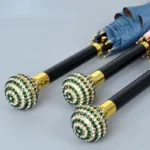 Parapluies luxe avec poignées strass dorées et vertes, design élégant, parfaits pour un style raffiné et sophistiqué.