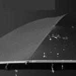 Grand parapluie résistant, design élégant avec surface perlée de gouttes de pluie, idéal pour une protection optimale contre les intempéries.