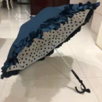 Parapluie femme semi-automatique bleu marine à pois noirs avec bordure frisée, idéal pour un style élégant et pratique.