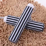 Parapluies rayés noir et blanc, design unique, posés sur un tapis beige – parfaits pour rehausser votre style sous la pluie.