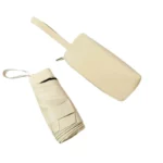 Mini parapluie compact avec pochette élégante en cuir beige, idéal pour une protection stylée contre la pluie.