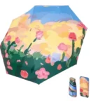 Mini parapluie vintage avec motif floral de roses sur fond ciel bleu, compact et élégant, livré avec une housse assortie.