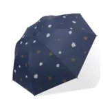 Parapluie bleu nuit avec motifs de nuages blancs et étoiles dorées, design épuré parfait pour un style moderne et élégant.