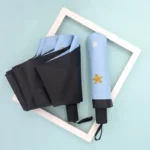 Assortiment de parapluies épurés colorés, noirs et bleu avec étoile, présentés sur fond turquoise pour la collection tendance.