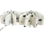 Parapluie pliable crème avec nuages souriants bleu et noir, design unique alliant style et protection pour les jours de pluie.