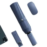 Parapluie compact gris avec lumière LED, design moderne, présenté avec son étui élégant et un smartphone pour illustrer sa taille.