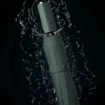 Parapluie moderne vert avec lumière LED, résistant à l'eau, design élégant entouré d'éclaboussures sur fond noir.