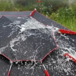 Parapluie de pêche, noir avec accents rouges, résistant au vent et à la pluie, parfait pour rester au sec lors de vos sorties en plein air.