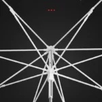 Parapluie de pêche résistant au vent avec structure intérieure robuste, nervures blanches et mât métallique, fond noir.