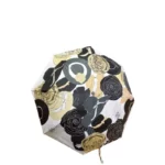 Parapluie femme pliant au design élégant, motifs floraux noir et jaune, pratique et compact pour une protection optimale contre la pluie.
