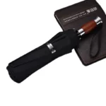 Parapluie golf chic noir avec poignée en bois élégant, parfait pour les amateurs de style et de fonctionnalité sur le terrain.