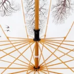 Parapluie japonais avec motifs branches et oiseaux, tiges en bois, revêtement crème élégant, parfaite alliance de style et tradition.