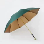 Parapluie luxe vert et beige avec manche doré et poignée noire strassée, accessoire élégant pour un style sophistiqué.