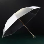 Parapluie luxe bicolore blanc et noir avec manche doré et poignée ronde, design élégant pour allier style et utilité par tous les temps.