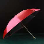 Parapluie luxe rouge avec poignée ronde, structure dorée, design moderne et raffiné, parfait pour compléter votre collection.
