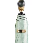 Parapluie luxe vert menthe avec poignée cristal et bandeau doré marqué, idéal pour un style élégant sous la pluie.