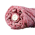 Parapluie luxueux plié, motif floral rose et blanc, bouton doré central, alliant élégance et fonctionnalité contre la pluie.