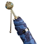 Parapluie luxe rétro avec poignée dorée ornée de strass et tissu bleu à motifs floraux, idéal pour allier élégance et protection.