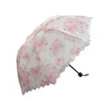 Parapluie mariage brodé avec motif floral rose, bordure en dentelle élégante, parfait accessoire chic pour votre journée spéciale.