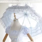 Parapluie mariage chic en dentelle bleue, accessoire élégant sur mannequin avec robe romantique, parfait pour un look raffiné.