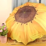 Parapluie jaune motif tournesol, design unique, accessoire élégant et pratique, posé près d’un pot décoratif orné de roses.