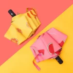 Parapluies originaux motifs fruits orange et pastèque, design coloré et fun, parfaits pour égayer les jours de pluie.