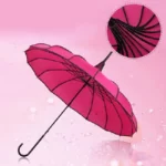 Parapluie vintage fuchsia à rayons noirs, design original et élégant, fond rose, idéal pour allier style et protection sous la pluie.